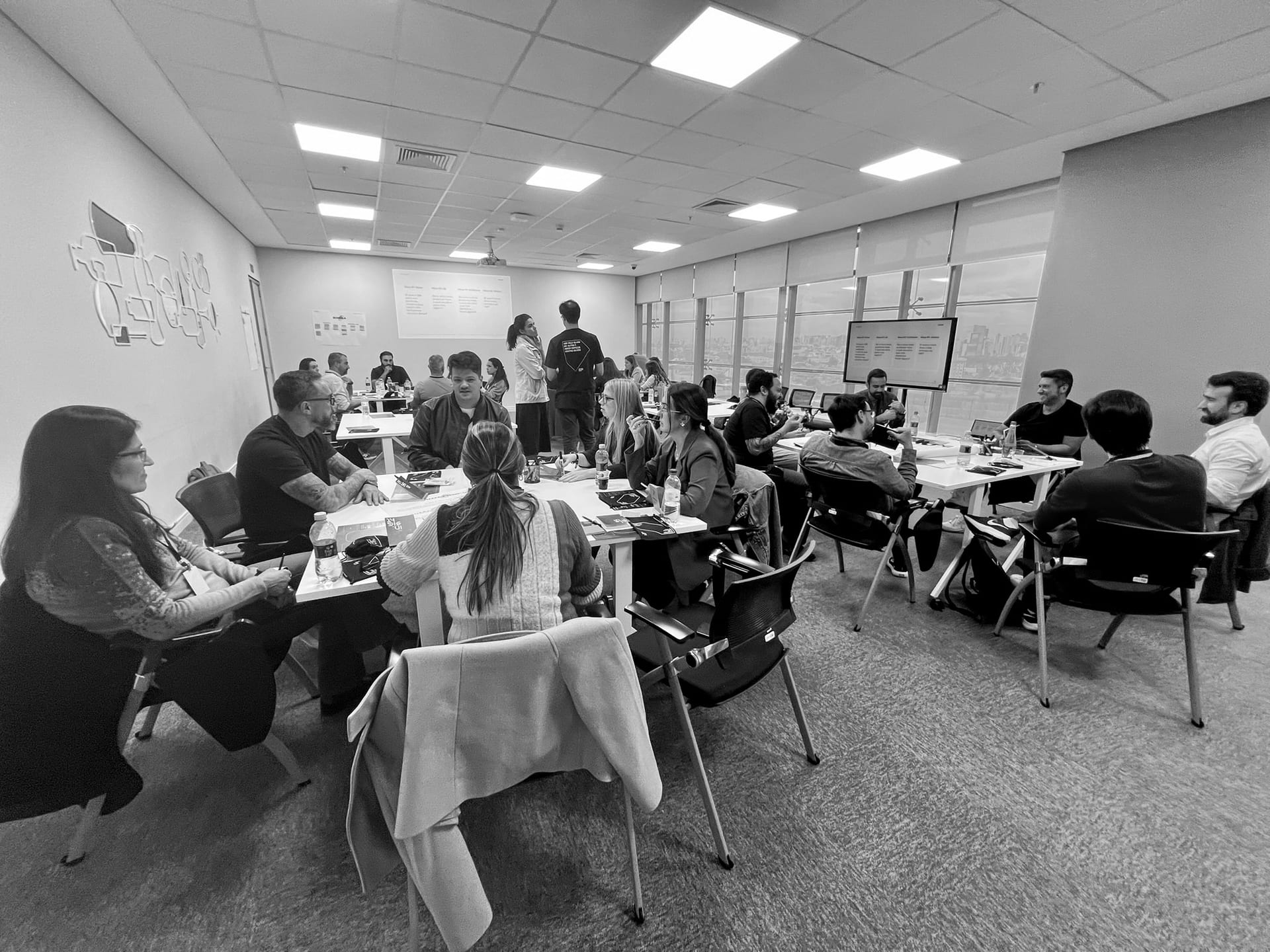 Participantes colaborando no mapeamento visual de interfaces e novas responsabilidades na estrutura corporativa